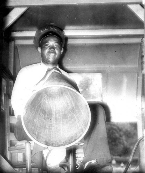 Skipper Manning Lockett aboard a Rainbow Springs submarine around 1950, holding a megaphone, wearing a Rainbow Springs cap